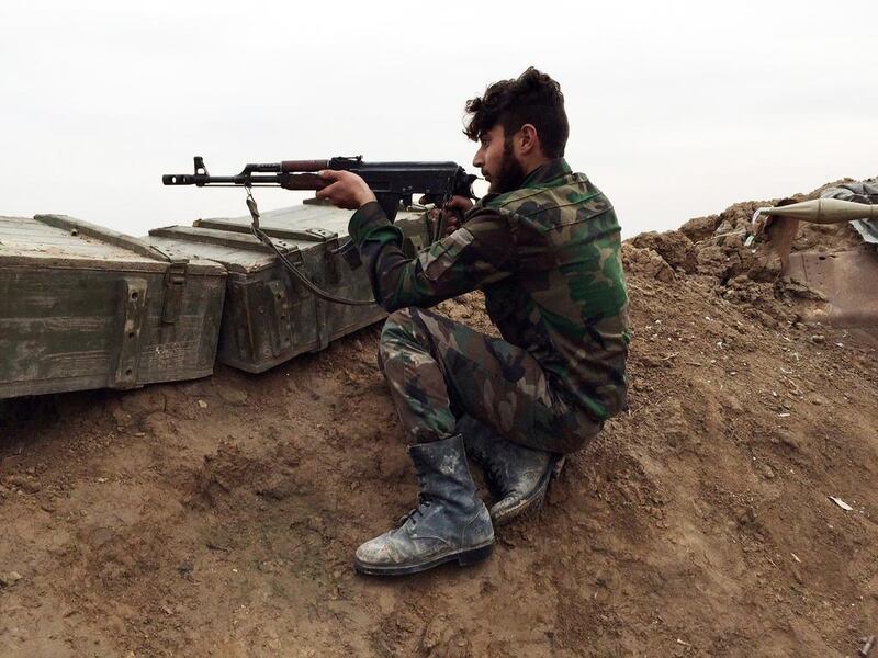 A pro-Assad gunman holds a position at a military airport held by Syrian troops and pro-regime militias in the northeastern Syrian city of Deir Ezzor on December 12, five days after they repelled an attack by militants. AFP Photo