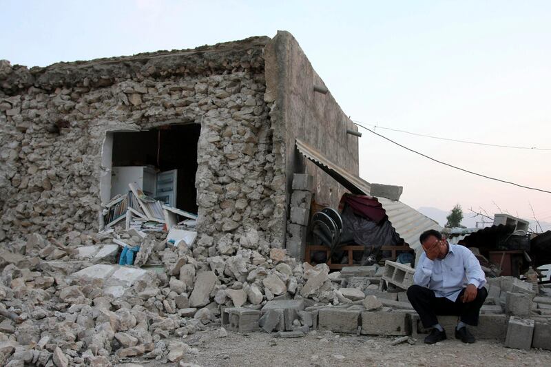An Iranian man reacts as he sits among ruins of a building after an earthquake struck southern Iran, in the city of Shonbeh, Iran, Tuesday, April 9, 2013. A 6.1 magnitude earthquake killed at least 37 and injured hundreds more in a sparsely populated area in southern Iran on Tuesday, Iranian officials said, adding that it did not damage a nuclear plant in the region. (AP Photo/Fars News Agency, Mohammad Fatemi) *** Local Caption ***  Mideast Iran Earthquake.JPEG-05d6d.jpg