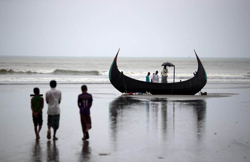 People look at a boat that capsized with a group of Rohingya refugees in it at Bailakhali, near Cox's Bazar, Bangladesh, October 31, 2017. REUTERS/Hannah McKay