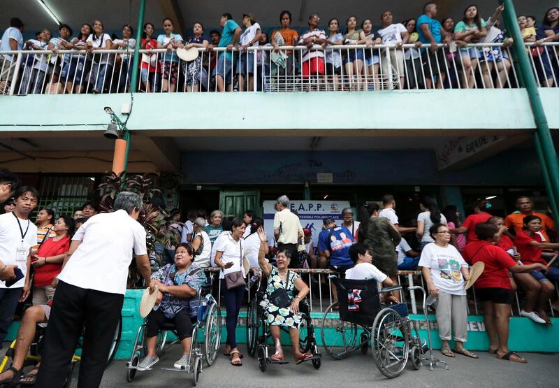 Manila residents wait in line to vote at a school.  AP Photo