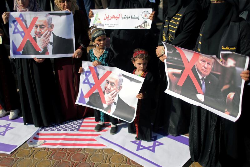 Palestinians stepping on representations of Israeli and US flags hold crossed-out posters depicting US President Donald Trump and Israeli Prime Minister Benjamin Netanyahu during a protest against Bahrain's workshop for US peace plan, in the southern Gaza Strip. Reuters