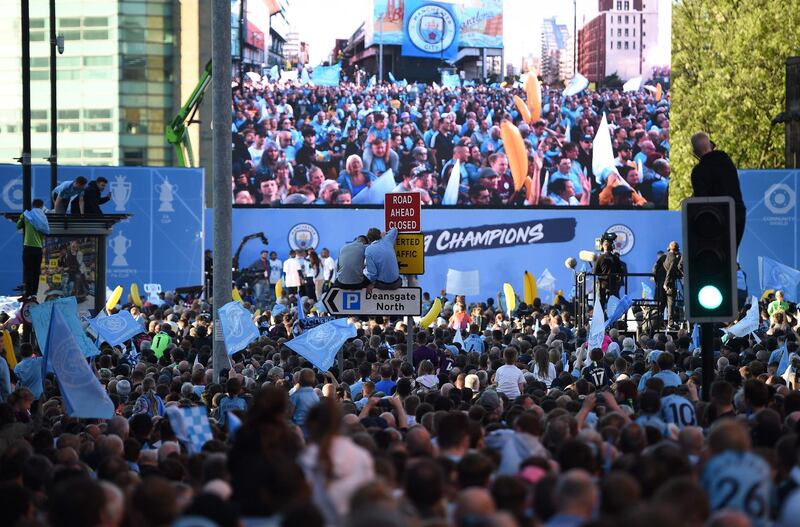 Manchester City football fans line the streets as they try to see the team show off the trophies in an open-top bus parade through Manchester, northern England, to celebrate winning the 2019 Premier League title, the FA Cup and English League Cup. Pep Guardiola saluted Manchester City's history makers after they clinched the domestic treble with a swaggering 6-0 rout of Watford in the FA Cup final on Saturday. Just a week after winning a second successive Premier League crown, City's record-equalling FA Cup final victory made them the first English club to win the English title, FA Cup and League Cup in the same season.  AFP