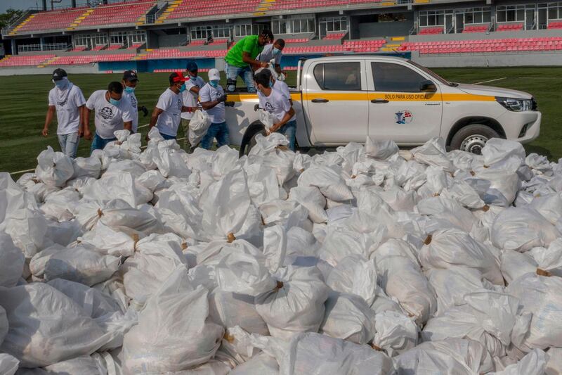 Volunteers of "Panama Solidarity Plan" load bags with food at Maracana Stadium in Panama City. AFP