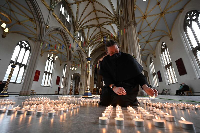 A verger lights one of 4,161 candles representing each death from Covid-19 in Lancashire county, following a service by Dean of Blackburn, Peter Howell-Jones at Blackburn Cathedral. AFP