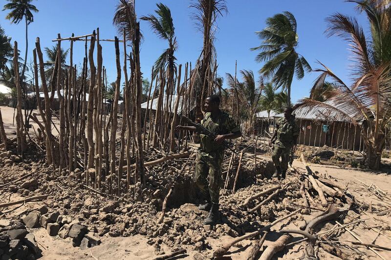 Mozambican Army soldiers bring down a structure torched by attackers to be rebuilt as shelter for people fleeing the recent attacks, in Naunde, northern Mozambique, on June 13, 2018. - Until last week, Mozambique's northern district of Macomia was a remote and peaceful place, surrounded by dense tropical forests. Today, that tranquility has been brutally shattered and replaced by fear and suspicion. Macomia has become the latest target of a shadowy jihadist force that has terrorised the country's far north since last October, claiming more than 30 lives. In the coastal village of Naunde, seven people were hacked to death and 164 houses were set alight. (Photo by Joaquim NHAMIRRE / AFP)