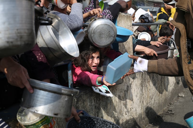 Palestinians wait to receive food aid in Rafah. AP