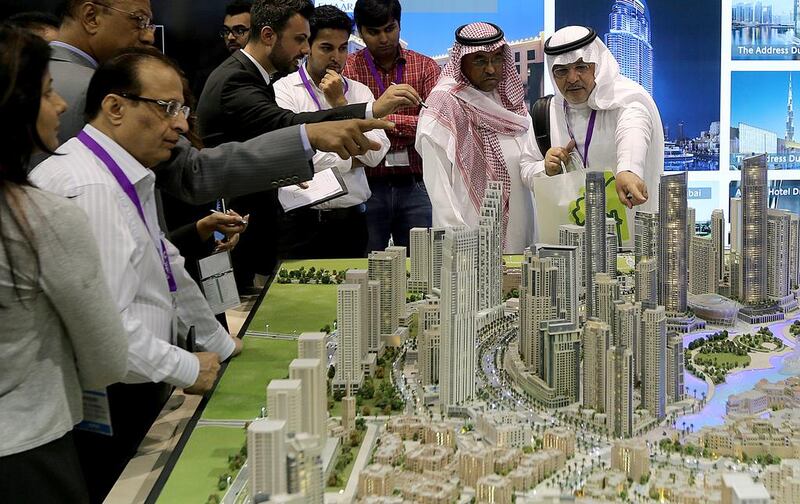 Visitors look at scaled versions of Emaar's Downtown Dubai projects at the opening day of Cityscape Global. Satish Kumar / The National