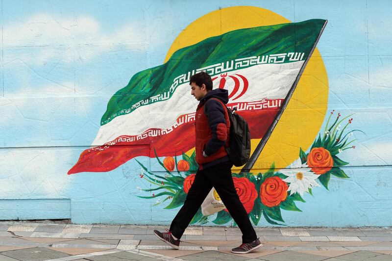epa08117343 An Iranian boy walk past next to a wall painting of Iran’s national flag in a street of the capital city of Tehran, Iran, 10 January 2020. The US administration on 10 January 2020 announced additional sanctions against Iran following tension between Iran and US after a US targeted airstrike killing of Iranian top general Qasem Soleimani near Baghdad arport on 03 January, and airstrike by Iran to US military bases in Iraq.  EPA/ABEDIN TAHERKENAREH