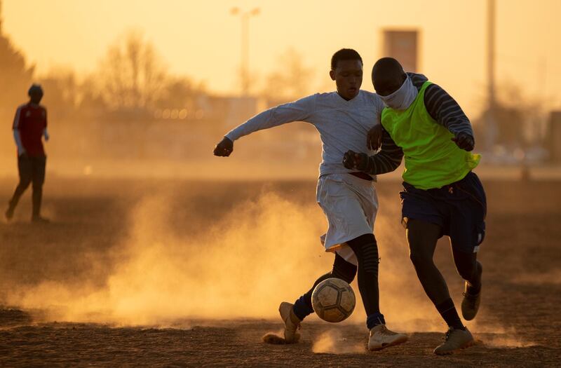 People play soccer on a dusty field in Soweto, South Africa. South African president Cyril Ramaphosa announced that the entire country will move to lockdown alert level 2 from Tuesday. AP Photo
