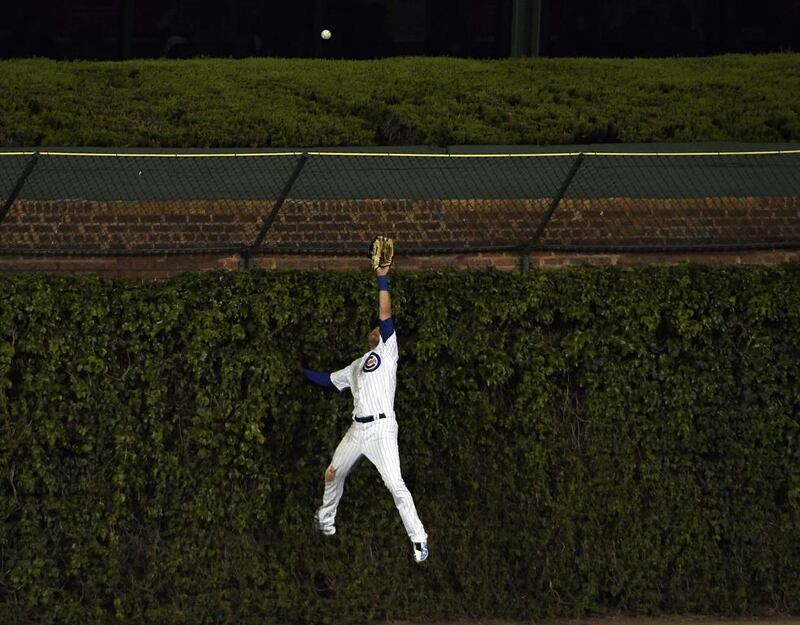 Chicago Cubs’s Albert Almora Jr jumps in vain as Justin Ruggiano scores a home run for the San Francisco Giants at Wrigley Field. David Banks / Getty Images / AFP