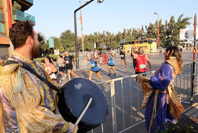 People dressed in traditional costumes encourage the runners. AFP
