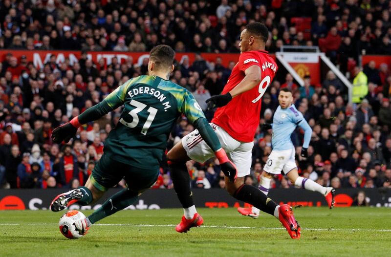 Manchester United's Anthony Martial attempts to chase down a clearance from Manchester City manager Ederson. Reuters