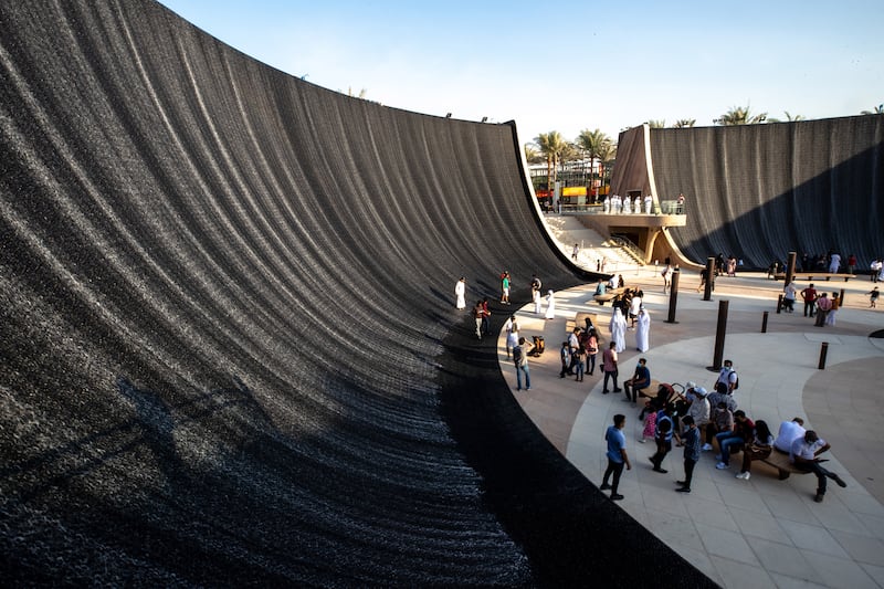 Visitors walk in the Expo 2020 Dubai Surreal waterfall area. Victor Besa / The National.