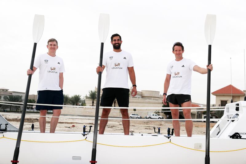 From left, Oliver Amos, Paris Norriss and Harry Amos beside the rowing boat in Dubai. Pawan Singh / The National