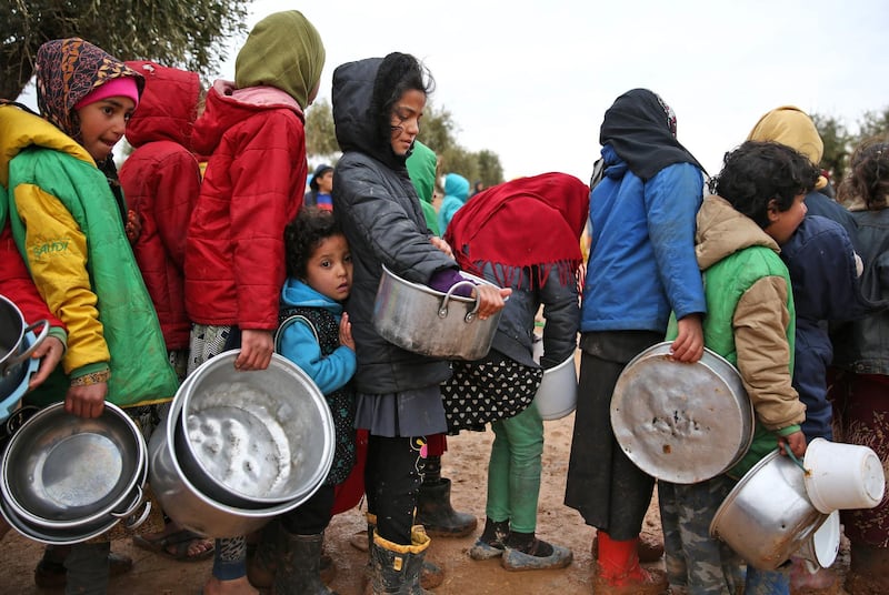 Syrian children queue to receive food distributed by humanitarian aid workers at a makeshift camp near the village of Yazi Bagh, about six kilometres from the Bab Al Salamah border crossing between Syria and Turkey. AFP