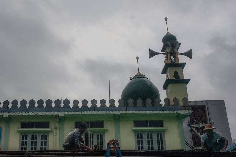 Men work on repairing the roof of a mosque in Yangon on May 30, 2017, during  Ramadan. Though they are only a small minority, Muslims have been present in Myanmar for centuries. But now many feel unwelcome in their homeland. Ye Aung Thu / AFP 