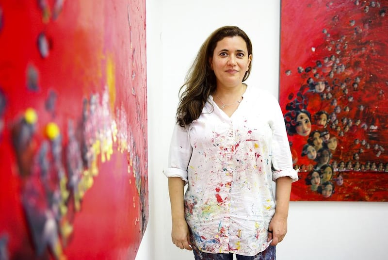 The Saudi Arabian painter Hadil Moufti in her studio in the Al Fahidi neighbourhood of Dubai, with two of her works based on a photo of her niece. Lee Hoagland/The National 
