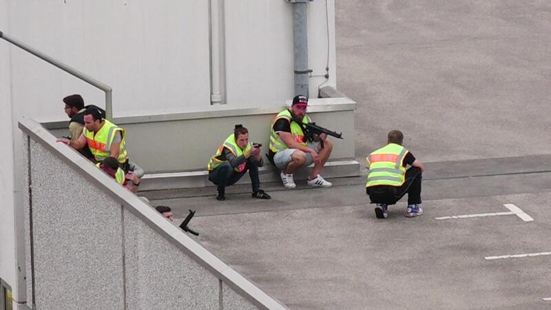 A screen grab taken from video footage shows plainclothes police officers taking cover in the car park of the OEZ shopping mall on July 22, 2016. dedinac / Marc Mueller via Reuters