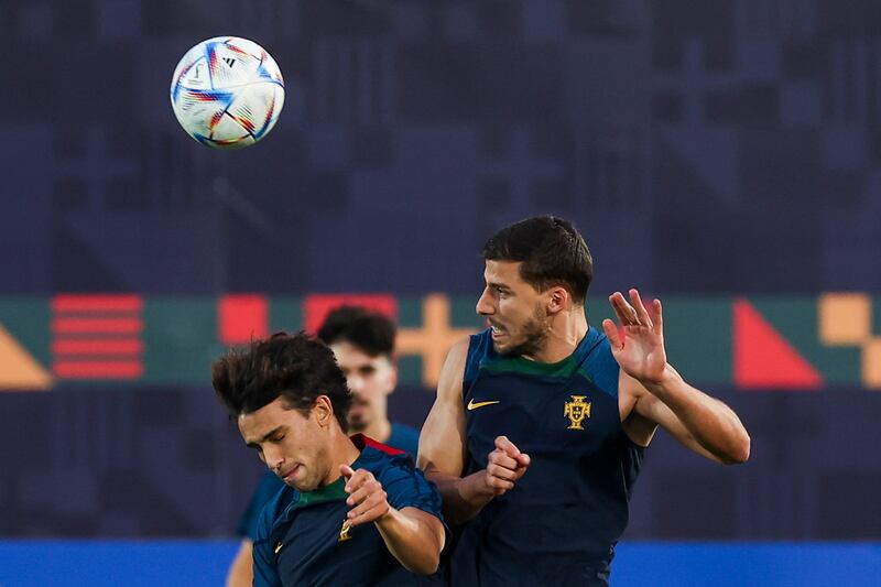 Portugal players Joao Felix and Ruben Dias challenge for a header. EPA