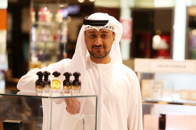 Ali Al Jabari, founder of the perfume brand AJ Arabia, with the Black and Gold versions of perfume bottles at Harvey Nichols store at Mall of the Emirates. Pawan Singh / The National