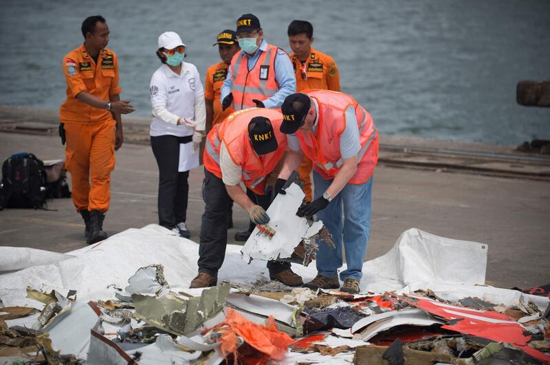 Officials from the US National Transportation Safety Board examine recovered debris at a port in Jakarta. AFP