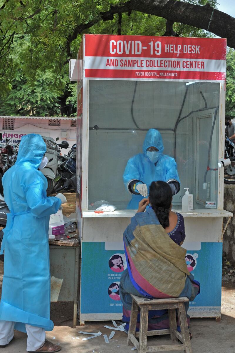 A health worker collects a swab sample of a woman at a government free testing centre in Hyderabad on July 17, 2020. AFP