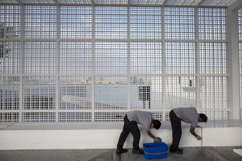 Workers clean outside the Louvre Abu Dhabi on March 15, 2020. EPA