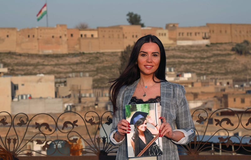 Dima Al Kaed, 29, a Syrian journalist and refugee living in Erbil, capital of the Iraqi Kurdistan region, holds a photo of herself dating from 2013 when she graduated from Damascus University.  During the war, Kaed lost her parents and her home. She arrived in Erbil at the end of 2020 without hope of returning. "I dreamt of changing the world, but instead the war changed mine," she said. AFP