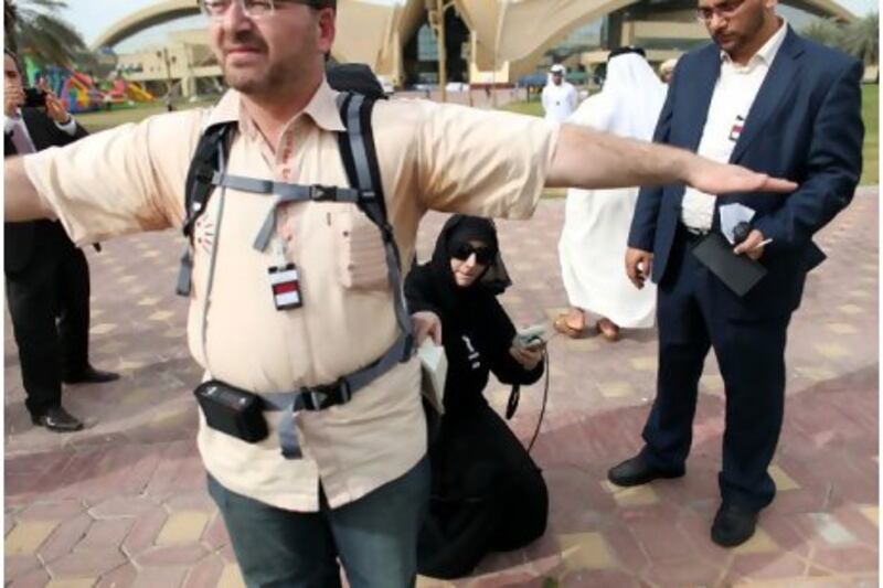 Zeinab al Husari searches for nuclear materials on Ahmed Sallam during a demonstration in Abu Dhabi yesterday.