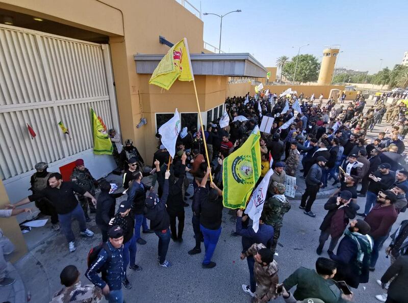 Protesters and militia fighters gather outside the main gate of the US Embassy in Baghdad. Reuters