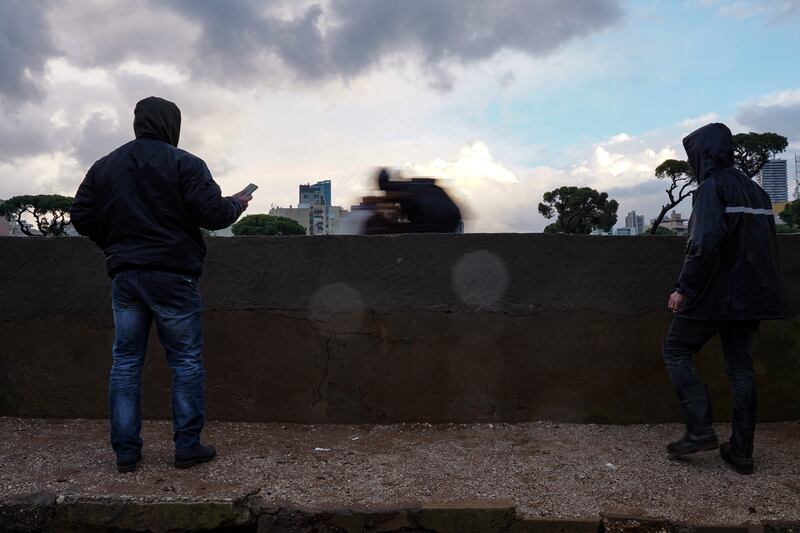 A trainer and handler record a horse's time as it races around the training ring.