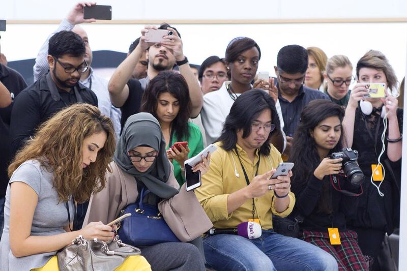 Media delegates use their iPhones at the the preview of the Apple Store in Mall of the Emirates. Reem Mohammed / The National
