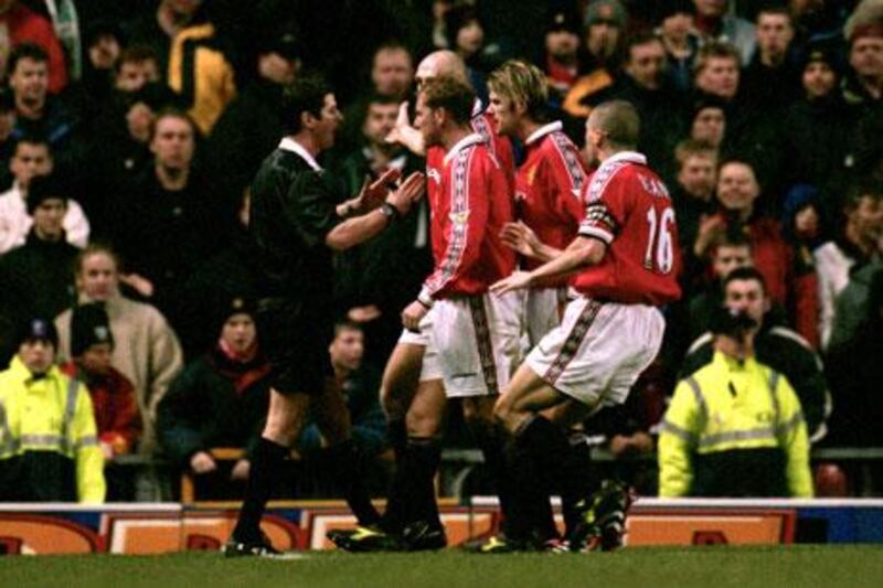 Manchester United players famously surround referee Andy D’Urso in 2000 after he had awarded a penalty against them at Old Trafford.