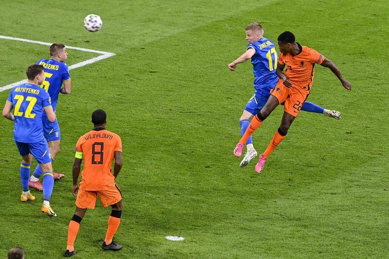 TOPSHOT - Netherlands' defender Denzel Dumfries (R) heads the ball to score the third goal during the UEFA EURO 2020 Group C football match between the Netherlands and Ukraine at the Johan Cruyff Arena in Amsterdam on June 13, 2021. / AFP / POOL / Olaf Kraak 
