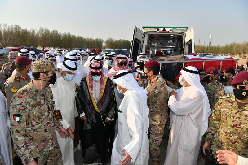 Kuwait's new Emir Sheikh Nawaf al-Ahmad Al-Sabah (C-L, in black), mask-clad due to the COVID-19 coronavirus pandemic, walking next to the bier of the late emir Sheikh Sabah al-Ahmad Al-Sabah upon its arrival for burial at the Sulaibikhat Cemetery.