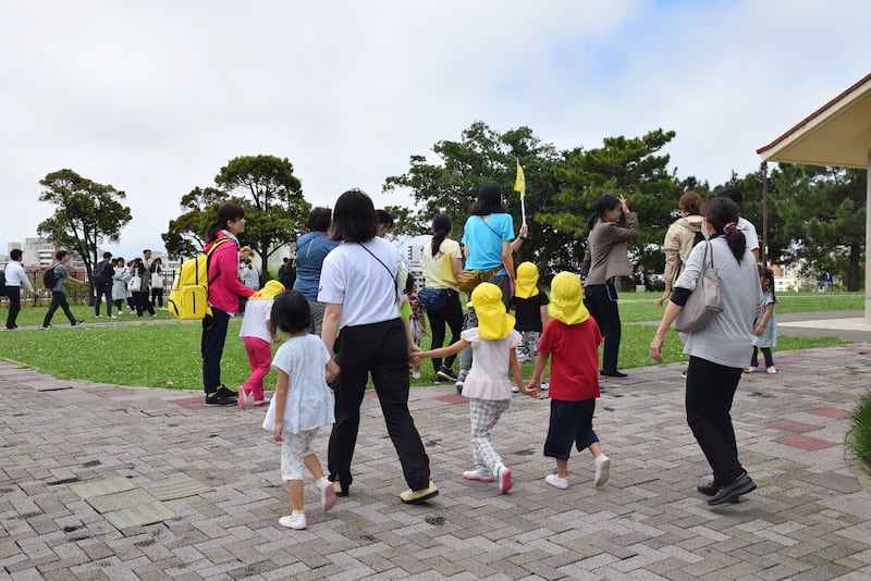 Children are taken to higher ground after the quake led to tsunami warning a Naha, Japan. AFP