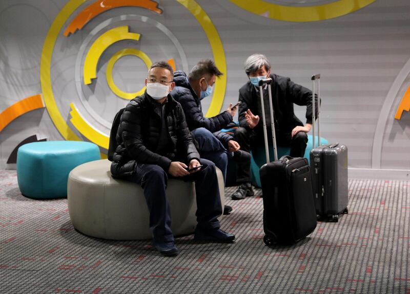 Travellers sit at Beijing Capital International Airport in Beijing, China. Reuters