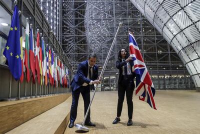 TOPSHOT - EU Council staff members remove the United Kingdom's flag from the European Council building in Brussels on Brexit Day, January 31, 2020. Britain leaves the European Union at 2300 GMT on January 31, 2020, 43 months after the country voted in a June 2016 referendum to leave the block. The withdrawal from the union ends more than four decades of economic, political and legal integration with its closest neighbours. / AFP / POOL / OLIVIER HOSLET
