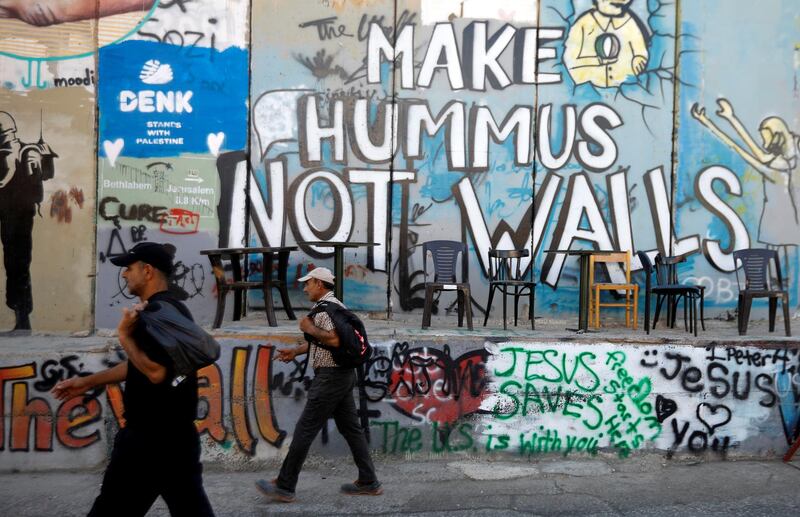 Palestinians walk past a section of the Israeli barrier, in Bethlehem, in the Israeli-occupied West Bank. Reuters