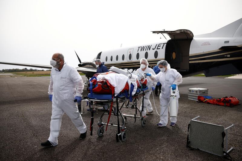 Medical staff members carry a patient suffering from Covid-19 on a stretcher after arriving on a plane at Vannes airport during a transfer operation from Lille to Vannes, France. Reuters