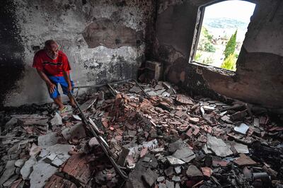 A man sorts through the rubble of a destroyed building in the aftermath of a forest fire near Meloula. AFP