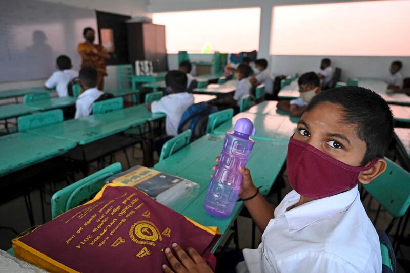 Sri Lankan children wearing face masks sit in a classroom after their school was reopened in Colombo.  AFP