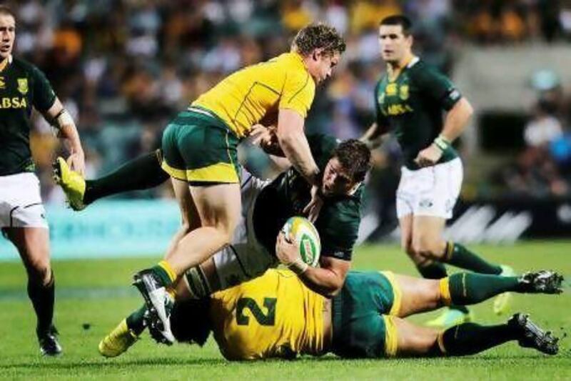 South Africa’s  Willem Alberts, centre, is tackled by Australia’s Michael Hooper, top, and Stephen Moore during their Rugby Championship Test match in Perth yesterday.