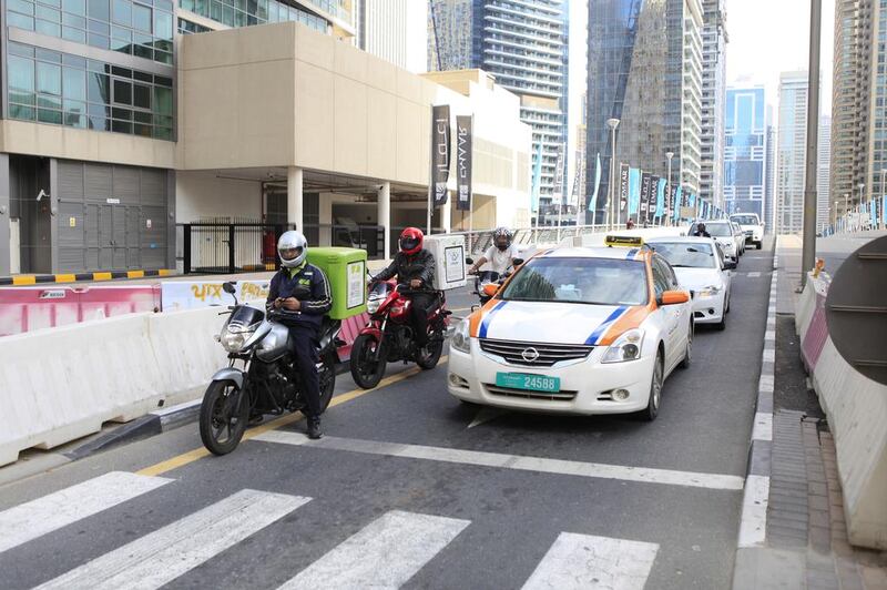 Food-delivery motorcyclists weave through Dubai traffic. Sarah Dea / The National, file