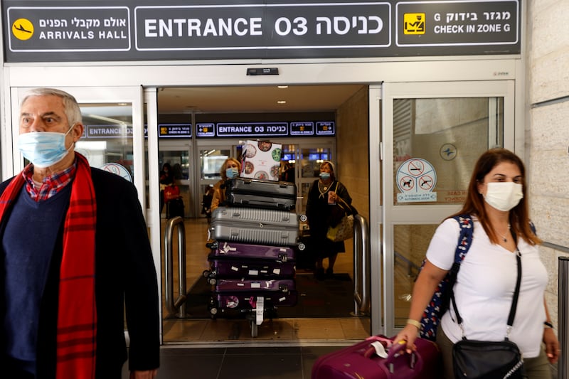 Masked travellers exit Israel's Ben Gurion International Airport.