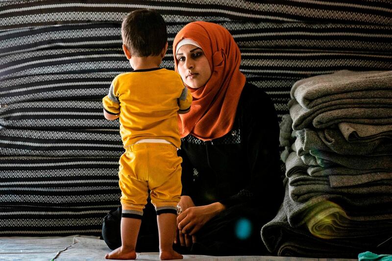 A volunteer carer looks after one of 24 orphaned children linked with Isis at a camp in the northern Syrian village of Ain Issa. AFP