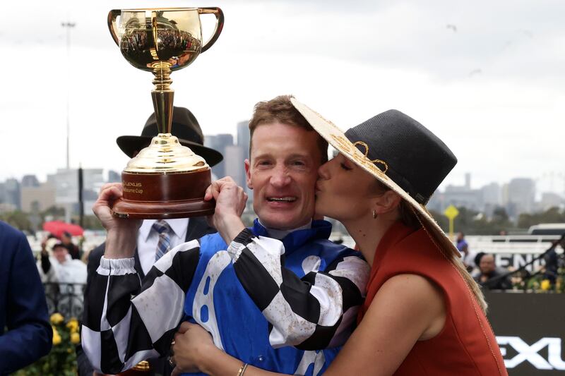 Jockey Mark Zahra holds his trophy as his wife, Elyse, kisses him after winning the Melbourne Cup horse race on Gold Trip. AP Photo 