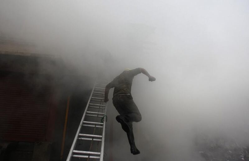 A firefighter jumps from a ladder during a fire in downtown Srinagar. Danish Ismail / Reuters