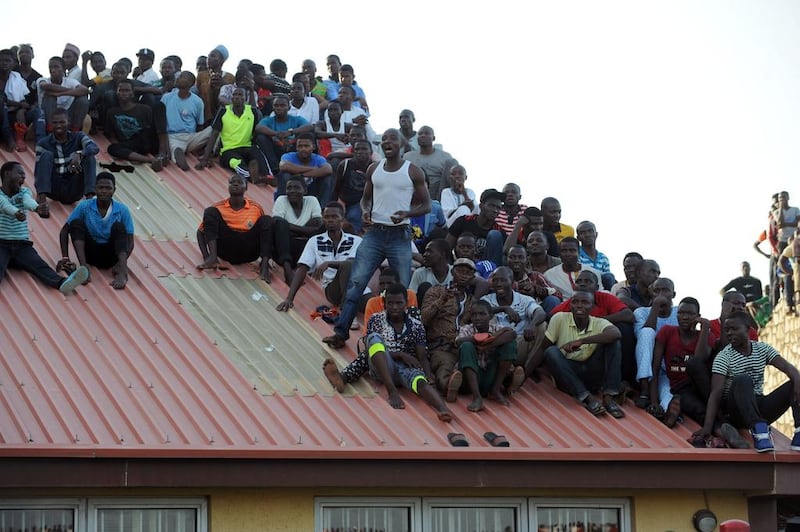 Supporters sit on the roof of a house to watch the African Cup of Nations qualification match between Egypt and Nigeria, on March 25, 2016, in Kaduna. AFP / PIUS UTOMI EKPEI