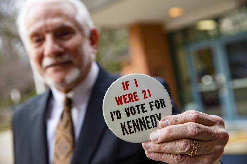 A man shows off his political button that says If I were 21 Id vote for Kennedy outside of the Taylor Elementary School after casting his ballot in Arlington, Virginia. AFP